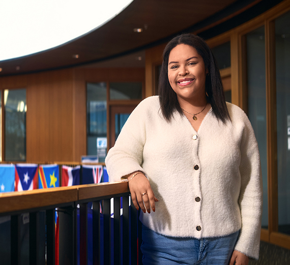 별이 그려진 티셔츠를 입은 여성이 난간에 기대어 있다.